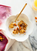 Orange almond granola in cereal bowl with milk