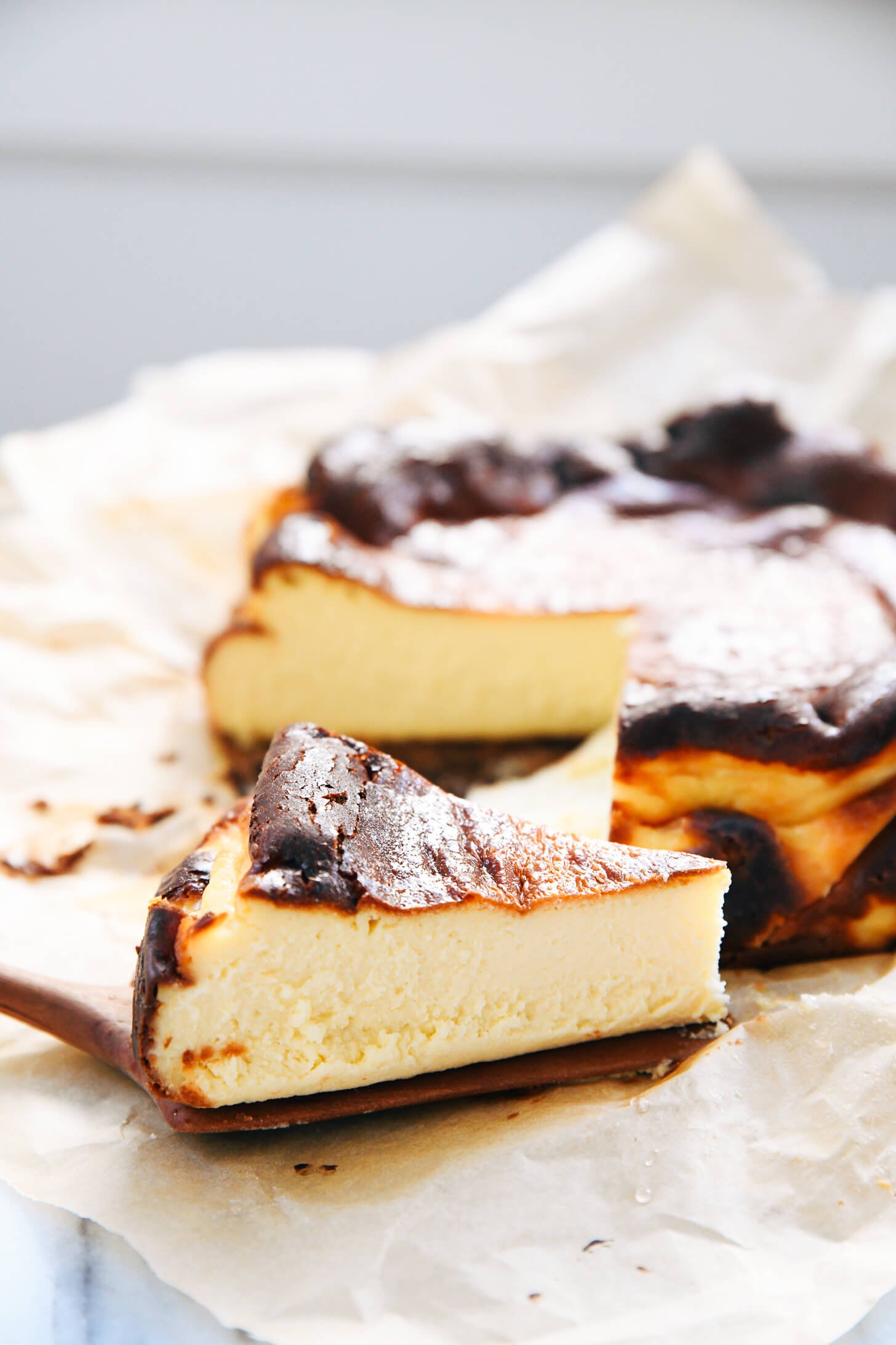 slice of Basque cheesecake next to cheesecake